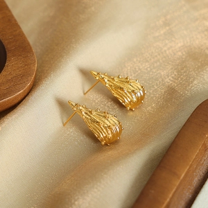 Irregular textured thorn stud earrings plated in 18K gold on elegant silk background