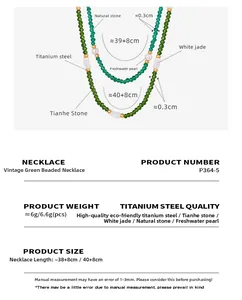 Macro detail of emerald stone and freshwater pearl necklace with gold-plated titanium beads