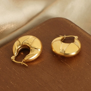 Boucles d'oreilles créoles dorées texturées sur présentoir en noyer avec satin chic