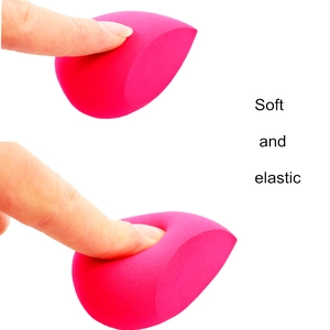 Macro view of pink teardrop makeup sponge being pressed to show soft elastic texture