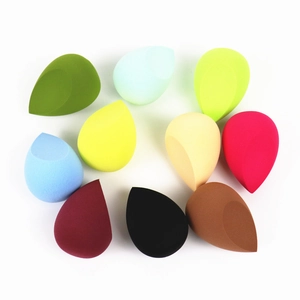 Set of 9 colorful teardrop makeup sponges with slanted edges on white background