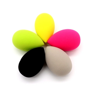 Top view of five colorful teardrop makeup sponges arranged in a petal shape on white background