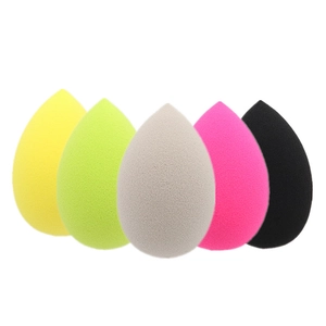 Detailed view of five teardrop makeup sponges in various colors on a white background