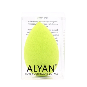 Close-up of light green teardrop makeup sponge in a clear plastic storage box