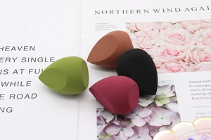 Macro detail of four assorted makeup sponges on a magazine for a high-quality aesthetic
