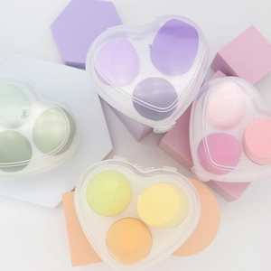 Heart-shaped case with three macaron color makeup sponges on geometric props