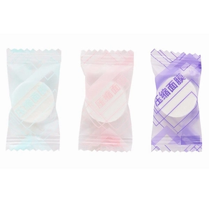 Three colorful individual candy-wrapped compressed facial masks on white background