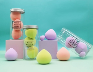 Macro view of four colorful teardrop makeup sponges in a clear travel canister