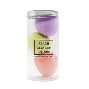 Three multi-colored peach makeup sponges in a transparent jar with a silver lid