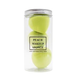Three peach-shaped makeup sponges in a clear storage jar with silver screw cap