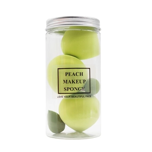 Jar of assorted peach-shaped makeup sponges in various shades of green with metal lid