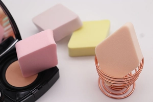 Detailopname van vier kleurrijke ruitvormige make-up sponsjes met een zachte textuur