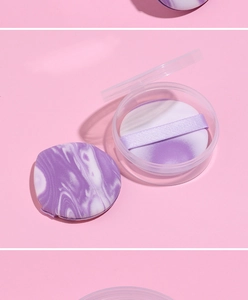 Detail of purple marble makeup puff in a transparent round storage box for foundation