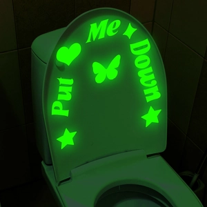 Macro view of luminous green 'Put Me Down' toilet stickers with stars and butterfly shapes