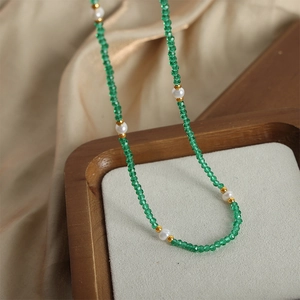 Handmade necklace with emerald green gemstone beads and freshwater pearls on satin
