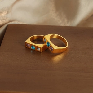 Golden geometric signet ring with inlaid blue heart, pink rectangle, and white cubic zirconia