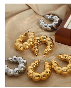 Vue détaillée des boucles d'oreilles en perles d'acier dorées et argentées