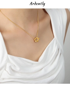 Gros plan d'un collier doré à double carrés emboîtés sur le cou d'un mannequin élégant
