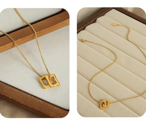 Détail de pendentifs rectangulaires imbriqués sur une fine chaîne en acier doré pour femme