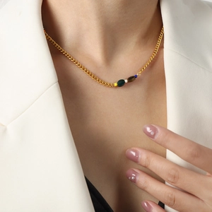 Bohemian gold chain necklace with five natural stones on a model in a white blazer