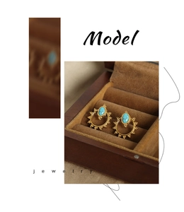 Detail of vintage gold sunburst earrings with turquoise stone in a brown velvet gift box