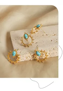 Macro detail of sun-shaped gold titanium earrings with inlaid turquoise stones