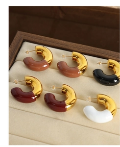 Detailed macro view of colorful enamel C-hoop earrings in gold-plated stainless steel