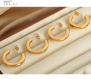 Detailansicht der polierten 18k Gold C-Ohrringe in einer hellen Samt-Schmuckschatulle