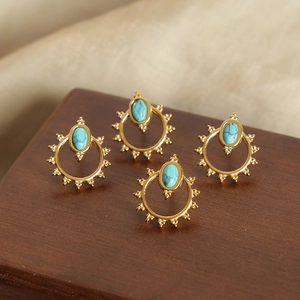 Bohemian sunburst titanium steel earrings with turquoise stones on wooden stand