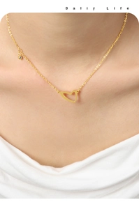 Dettaglio della collana con ciondolo a cuore dorato e zircone indossata sul collo