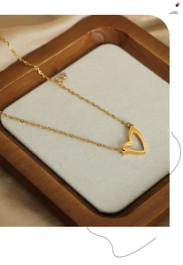 Dettaglio macro della collana con ciondolo a cuore dorato e pietre di zircone