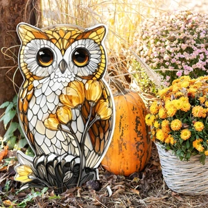 Stained glass owl garden stake decoration with floral patterns in an autumn yard