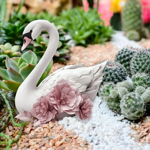White swan garden ornament with pink flowers detail in a succulent landscape