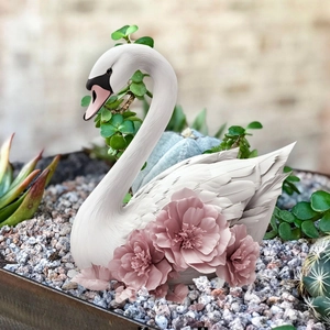 Detailed view of a white swan garden stake with pink floral relief and feather texture