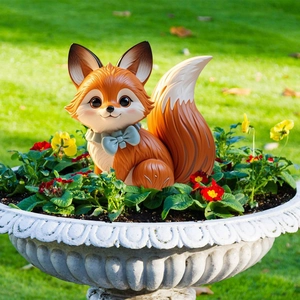 Close-up of a cute orange fox garden stake placed among colorful pansy flowers