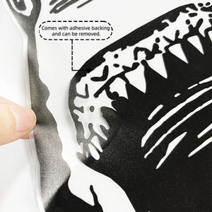 Close-up showing the adhesive backing removal process of the black shark wall sticker