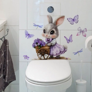 Détail d'un sticker lapin avec chariot de fleurs sur carrelage blanc de salle de bain