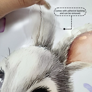 Détail montrant une main décollant l'autocollant lapin de Pâques de son support adhésif