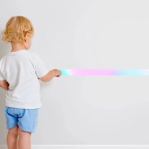 Detail van regenboogprojectorlamp die kleurrijke lichtprojectie op witte muur toont