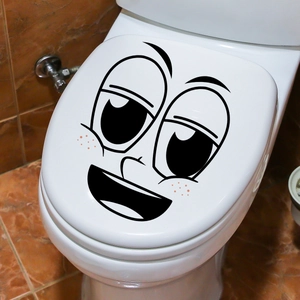 Grappige cartoon gezicht vinyl sticker aangebracht op een wit keramisch toiletdeksel