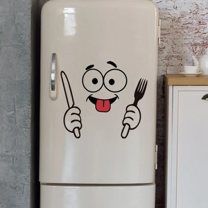 Detail van cartoon koelkaststicker met schattig gezicht en bestek op een witte wand