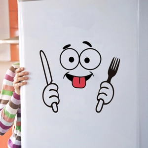 Detail van een grappige cartoon gezicht sticker met mes en vork op een witte koelkast