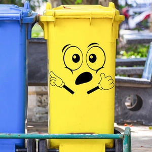 Grappige cartoon ogen en handgebaren stickers op een gele vuilnisbak voor buiten