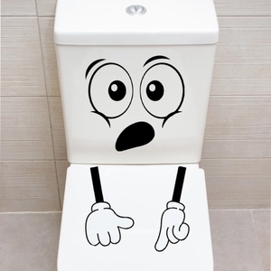 Detail van een grappige verrassingsgezichtsticker op een wit keramisch toiletdeksel