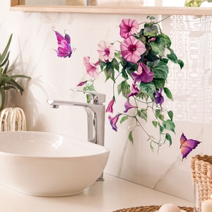 Détail de stickers muraux floraux colorés avec papillons sur carrelage de salle de bain
