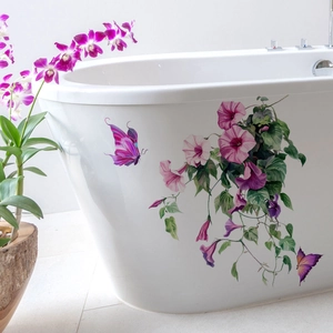 Détail de fleurs de liseron violettes et stickers papillons sur une baignoire blanche