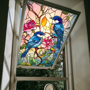 Detail of stained glass window film featuring blue birds and pink roses on a white window