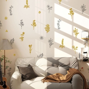 Macro detail of metallic floral and butterfly wall stickers in a cozy modern living room