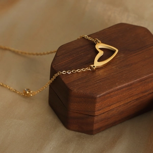 Collana minimalista placcata oro 18k con ciondolo a cuore e zircone su scatola di legno