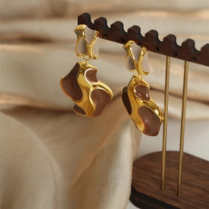 Irregular French style gold-plated drop earrings with brown enamel on a silk background